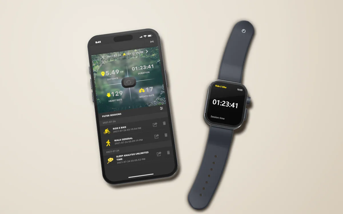 Rendered iPhone lying on a stone surface, showing a recorded session in the app — 5.49 km, 01:23:41, heart rate 129 and breath rate 17 over a map, above the list of sessions — beside a rendered Apple Watch with an illustrated face showing the same e-bike session's time